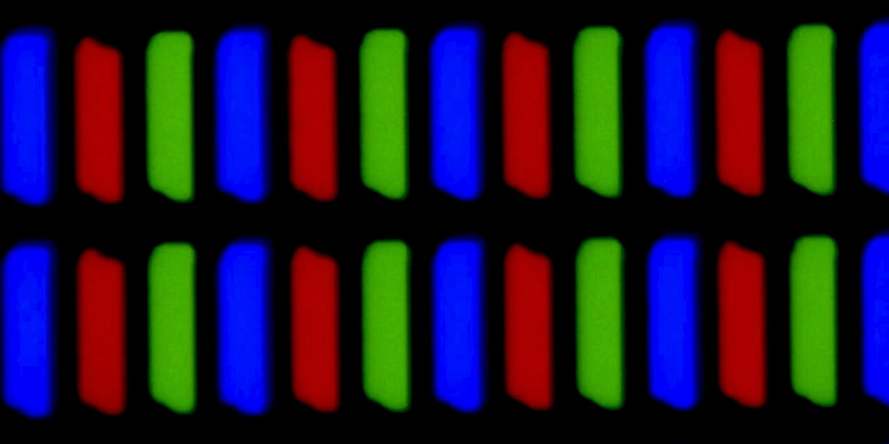 A laptop LCD screen magnified 300 times: rows of separate red, green and blue stripes on a black grid, three stripes to each pixel.